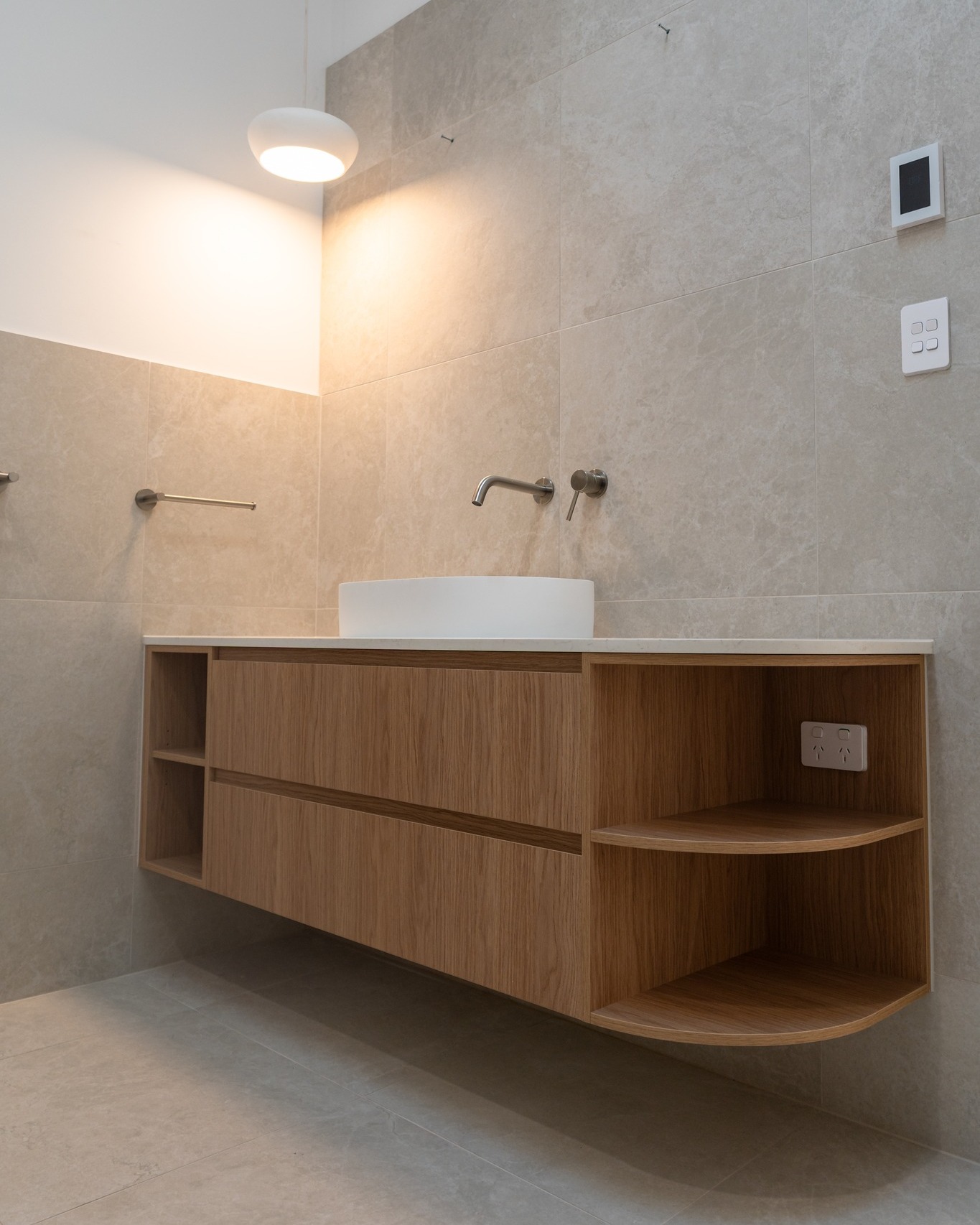 Floating oak bathroom vanity with open shelving and vessel sink