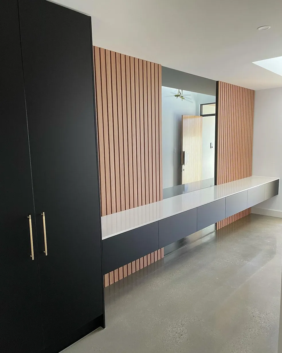 Matte black wardrobe panel with timber slat feature wall and floating sideboard